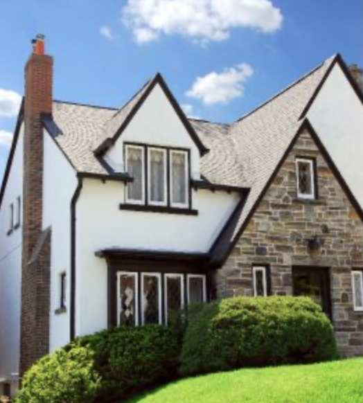 White stucco tudor styole home with dark trim